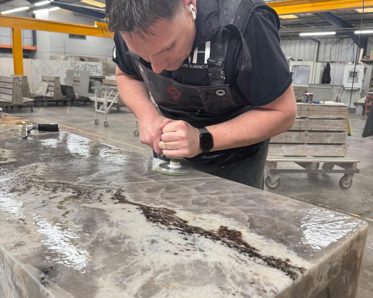RH Stone Surfaces fabricator polishing a granite kitchen worktop in our North East factory